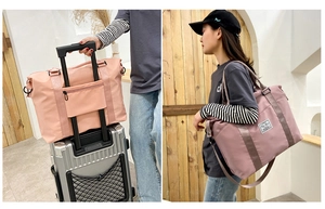 Pink nylon travel duffel bag with luggage sleeve and detachable shoulder strap detail