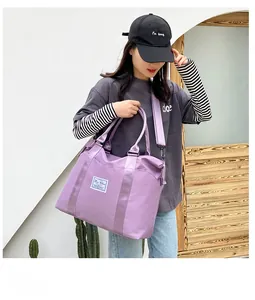Detail of purple nylon travel bag featuring woven handles and adjustable shoulder strap