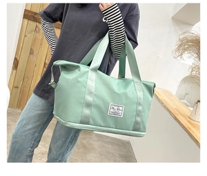 Detail of light green expandable gym bag showing waterproof fabric and large bottom compartment