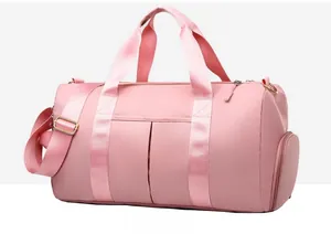Detail of pink waterproof gym bag showing dual handles, side shoe pocket, and golden buckles