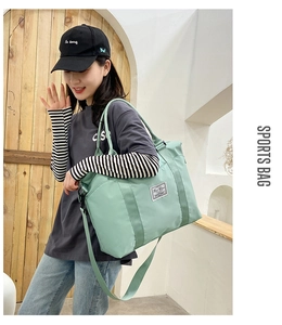 Detail of mint green nylon travel bag with reinforced straps and woven brand label