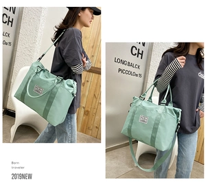 Detail view of mint green nylon travel bag with adjustable strap and waterproof texture