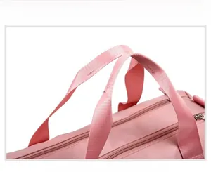 Detail of pink travel bag showing reinforced handles and dual metal zippers