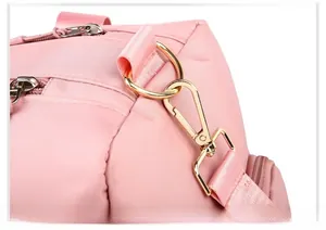Close-up of pink travel bag with durable metal hooks and detachable shoulder strap detail