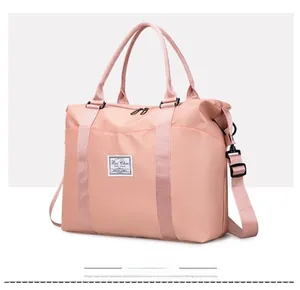 Pink waterproof nylon travel bag with dual handles and adjustable shoulder strap
