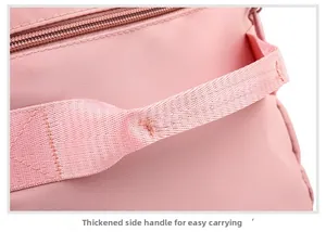Close-up of reinforced side handle on pink travel bag with durable stitching details