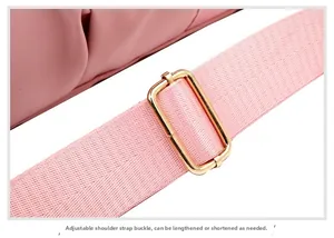 Detail of adjustable pink fabric strap with golden metal buckle for travel bags