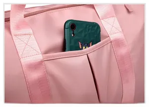 Close-up of a pink travel bag featuring a pleated front pocket for storage
