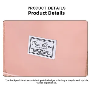 Detail of the pink travel bag featuring a white Bai Chao Enjoy Travel woven fabric label