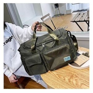 Dettaglio borsa fitness in nylon impermeabile verde oliva con multitasche su tavolo di legno