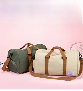 Detail view of canvas duffel bags in olive and beige with adjustable shoulder straps