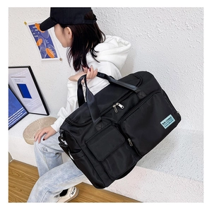 Dettaglio di un borsone sportivo in nylon nero con tasche multiple e zip in argento