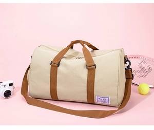 Detail of a beige canvas travel bag with brown straps and pink tennis racket accessories