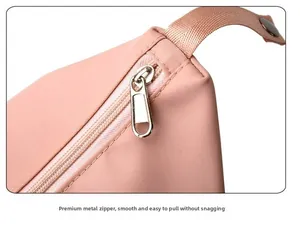 Detail of pink nylon travel bag featuring a smooth metal zipper and durable strap handle