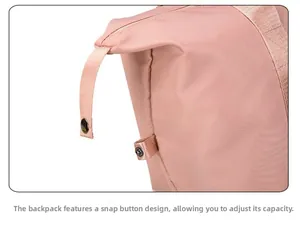 Detail view of side metal snap button for adjustable capacity on pink travel bag