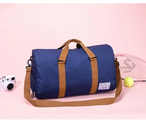 Detail view of navy canvas travel bag with brown handles and white brand label