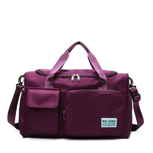 Dettaglio borsa sportiva viola con manici rinforzati e tasche portaoggetti frontali