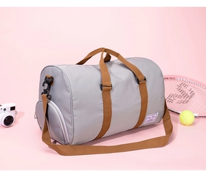 Detail of gray waterproof travel bag with brown straps and side shoe compartment