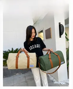 Waterproof canvas travel duffel bags in beige and olive green with durable brown handles