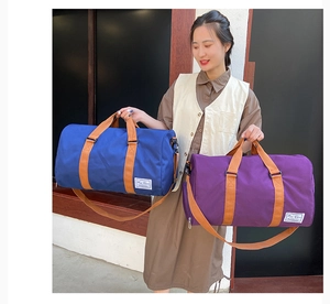 Blue and purple large capacity canvas travel bags held by model for sports and fitness