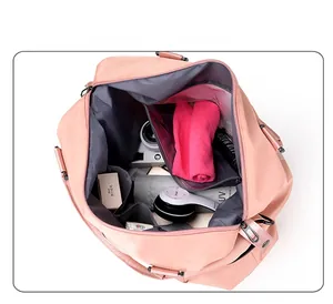 Interior view of pink nylon travel bag showing spacious compartments with various travel items