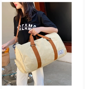 Detail of canvas travel bag with side zipper pocket and vintage woven label