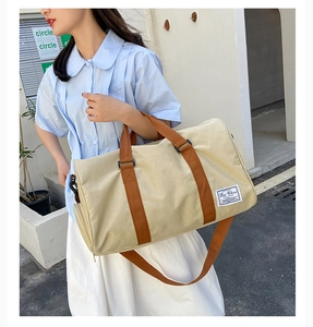 Large beige canvas travel bag featuring durable brown straps and metal hooks on outdoors