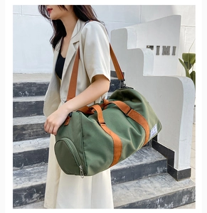 Close-up of olive green travel bag showing separate shoe compartment and orange straps