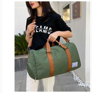 Detail of green canvas travel bag showing the side zipper compartment for shoes storage