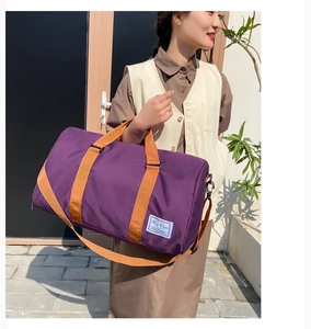 Close-up of purple water-resistant travel bag with brown straps and brand logo detail