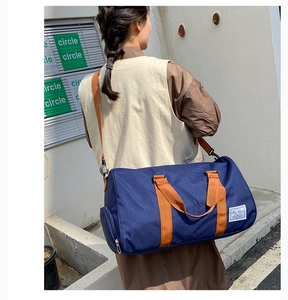 Detailed macro view of durable waterproof canvas travel bag with blue and orange straps