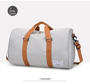 Detail view of the durable gray canvas travel bag with brown straps and brand logo