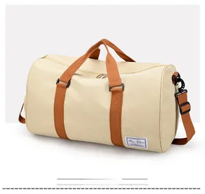 Detail of canvas travel bag with brown straps, side brand label and adjustable shoulder strap