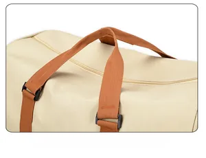 Detail of comfortable woven brown handles with reinforced stitching on a beige canvas travel bag