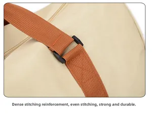 Detail of reinforced stitching and durable webbing handles on canvas travel bag