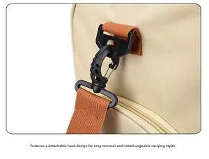 Detail of the detachable plastic hook and orange nylon strap on the canvas travel bag