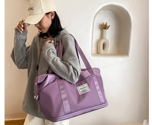 Detail view of large purple travel tote showing nylon fabric and reinforced strap handle
