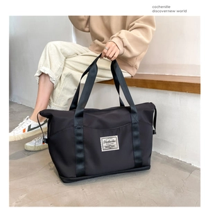 Close-up of black waterproof gym bag with reinforced woven handles and logo detail