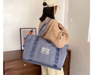 Close-up of a large blue waterproof travel bag for fitness and yoga with reinforced straps