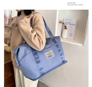 Close-up of lightweight blue nylon fitness bag with wide straps in minimalist room