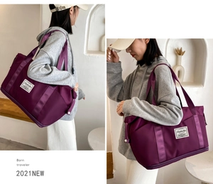 Detail view of purple waterproof travel bag showing reinforced straps and large capacity