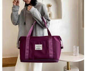 Detail view of purple fitness bag showing wet-dry separation shoe compartment and hand straps