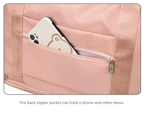 Detailed view of the back zipper pocket on pink travel bag holding a smartphone