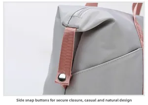 Detail showing high-quality side snap button and zipper on gray nylon travel bag