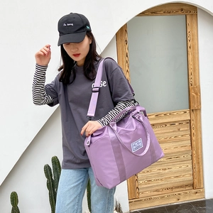 Large purple nylon travel bag with adjustable strap and top handles for women