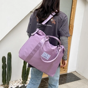 Large purple nylon travel bag with wet-dry separation shown on a model for outdoor use