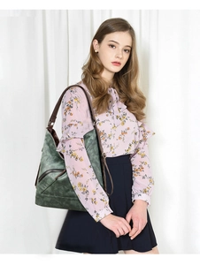 Détail d'un grand sac cabas vert vintage avec anses marrons porté par un mannequin