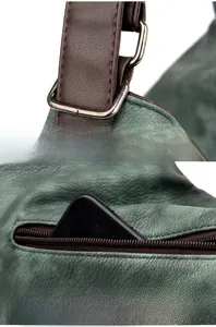 Détail du sac en cuir vert foncé avec anneau en D argenté et poche zippée à l'arrière