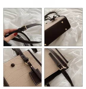 Detail view of crocodile pattern faux leather bag with bottom studs and adjustable strap