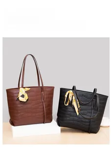 Detail of stone embossed tote bags with floral scarves in brown and black colors
